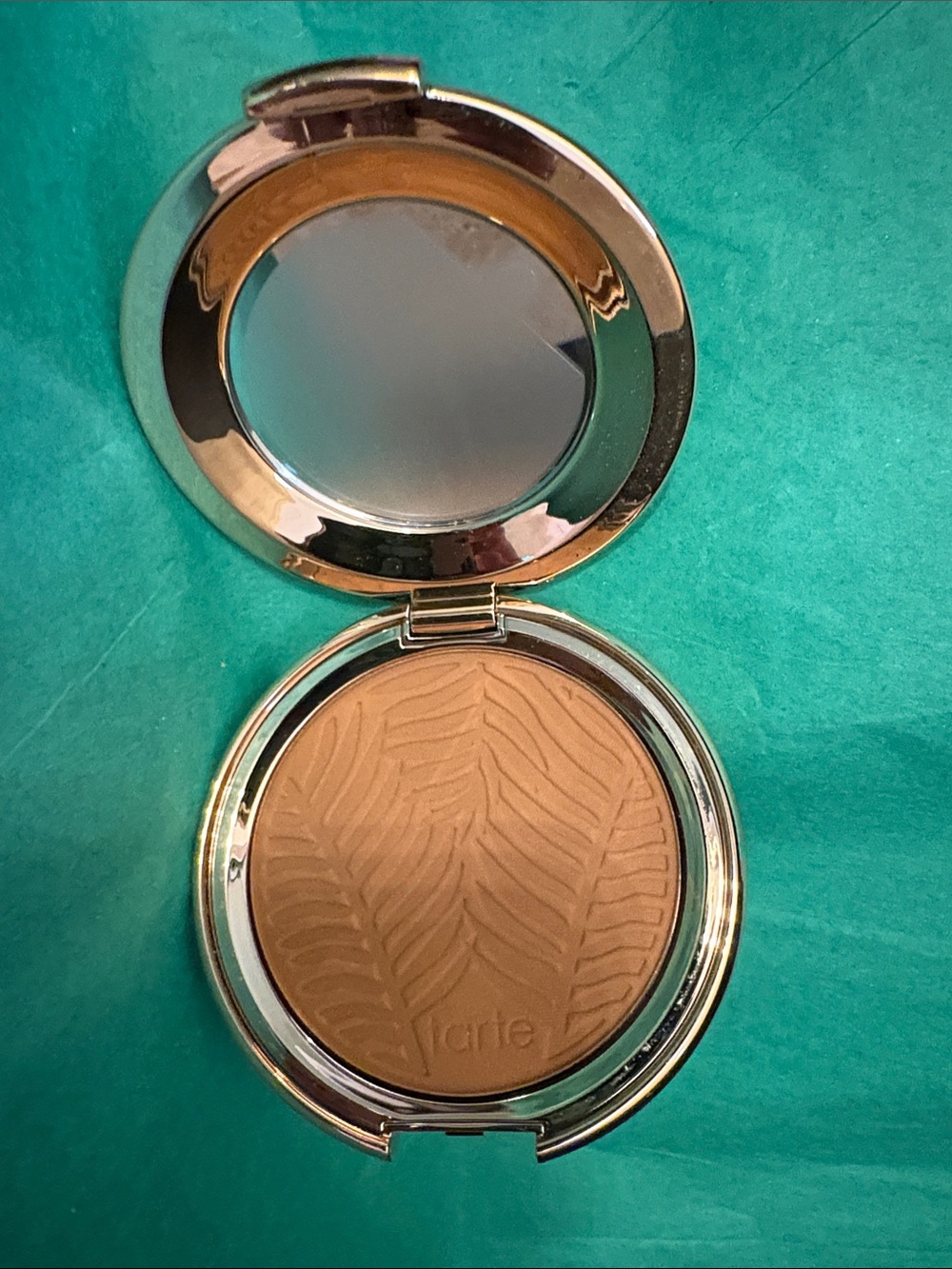 This appears to be a Tarte Amazonian Clay Blurring Powder Foundation compact fea